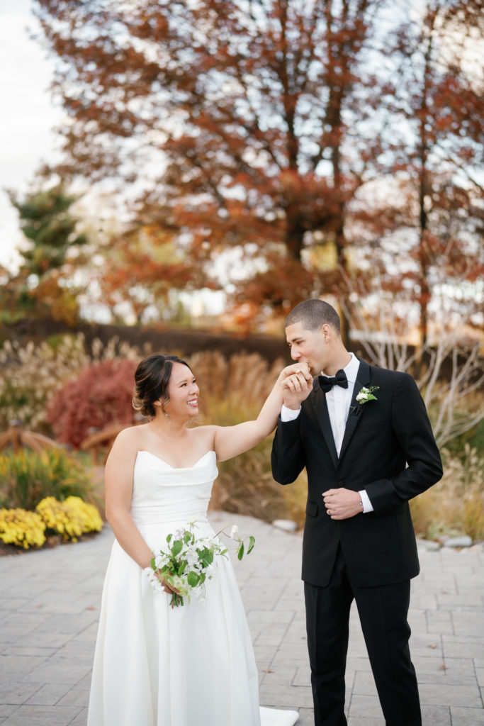 Colorado wedding seasons for fall foliage in the background with groom kissing bride's hand 